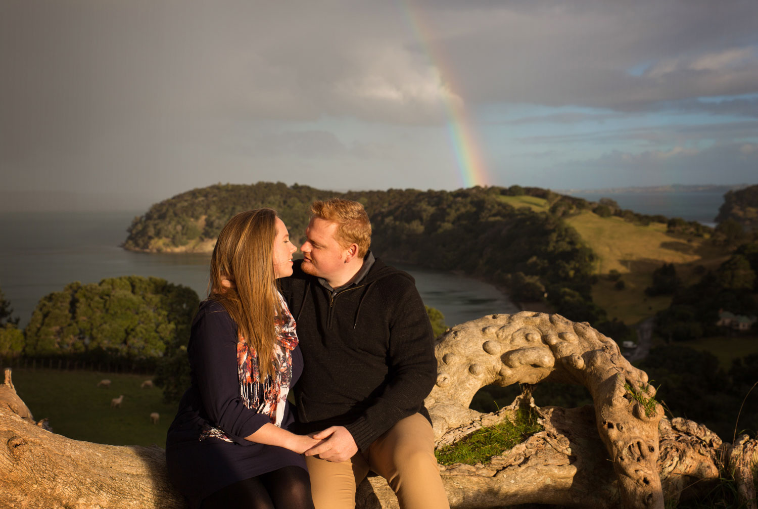 auckland engagement photo couple kissing with rainbow
