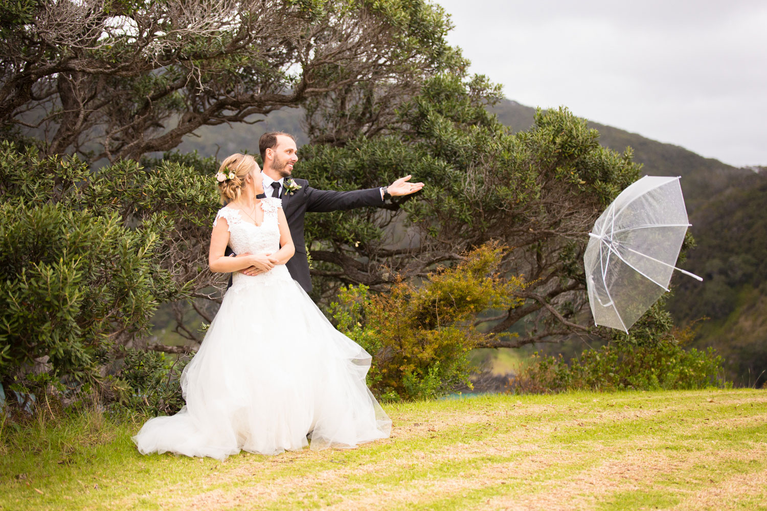 bay of islands wedding groom throwing away umbrella