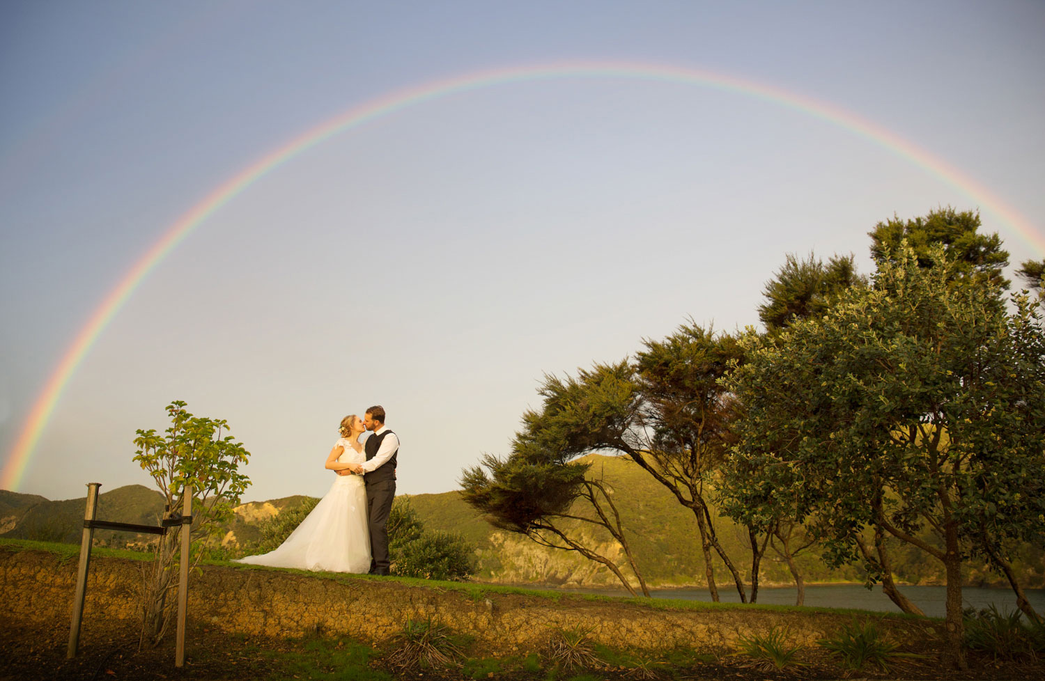 bay of islands wedding couple under rainbow