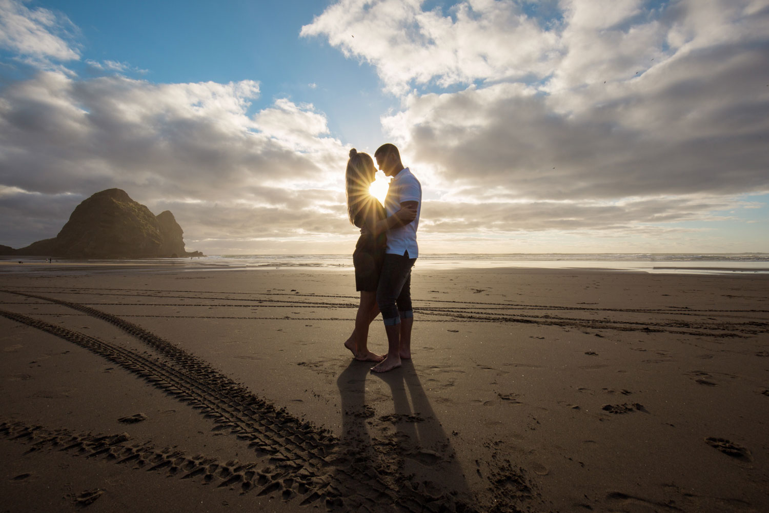 couple sunset piha beach