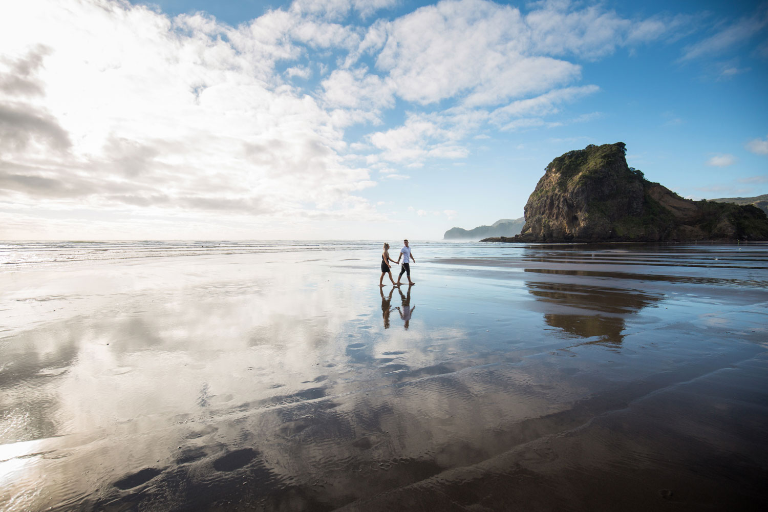 couple walking across water reflection