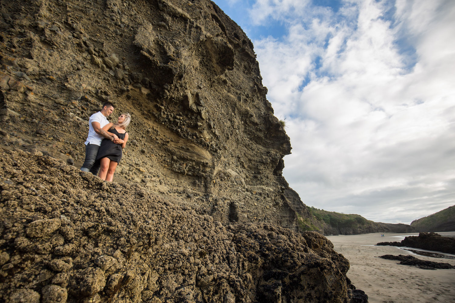 couple on rocks piha beach