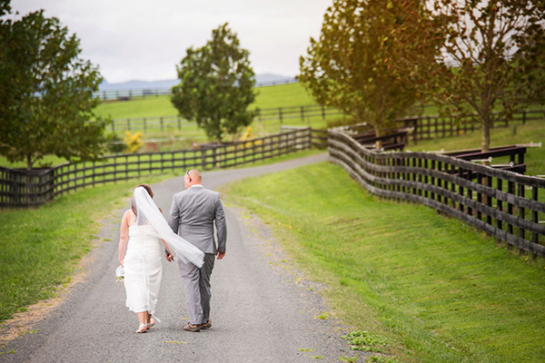 couple walking at a barn wedding