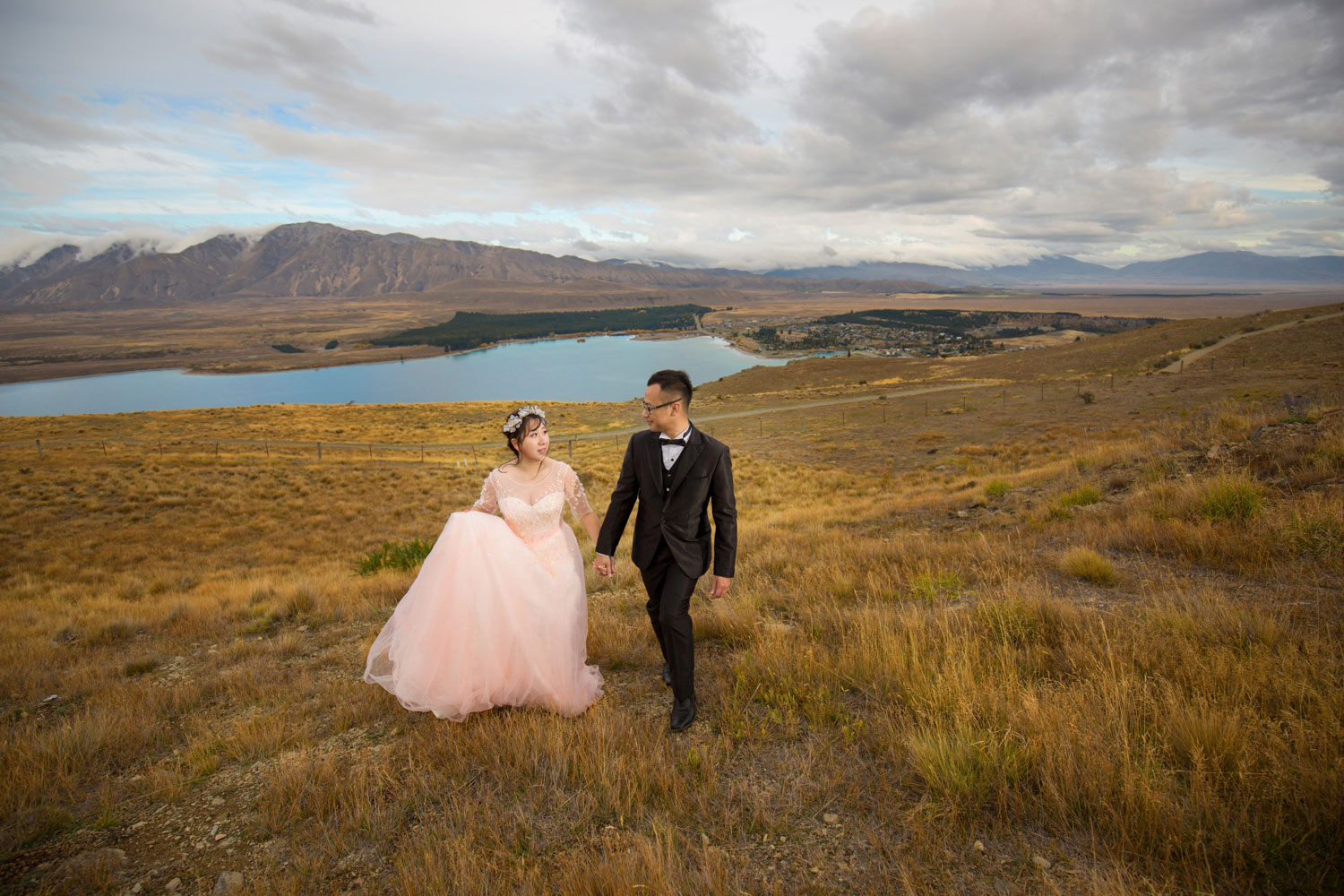 couple holding hands walking up mountain