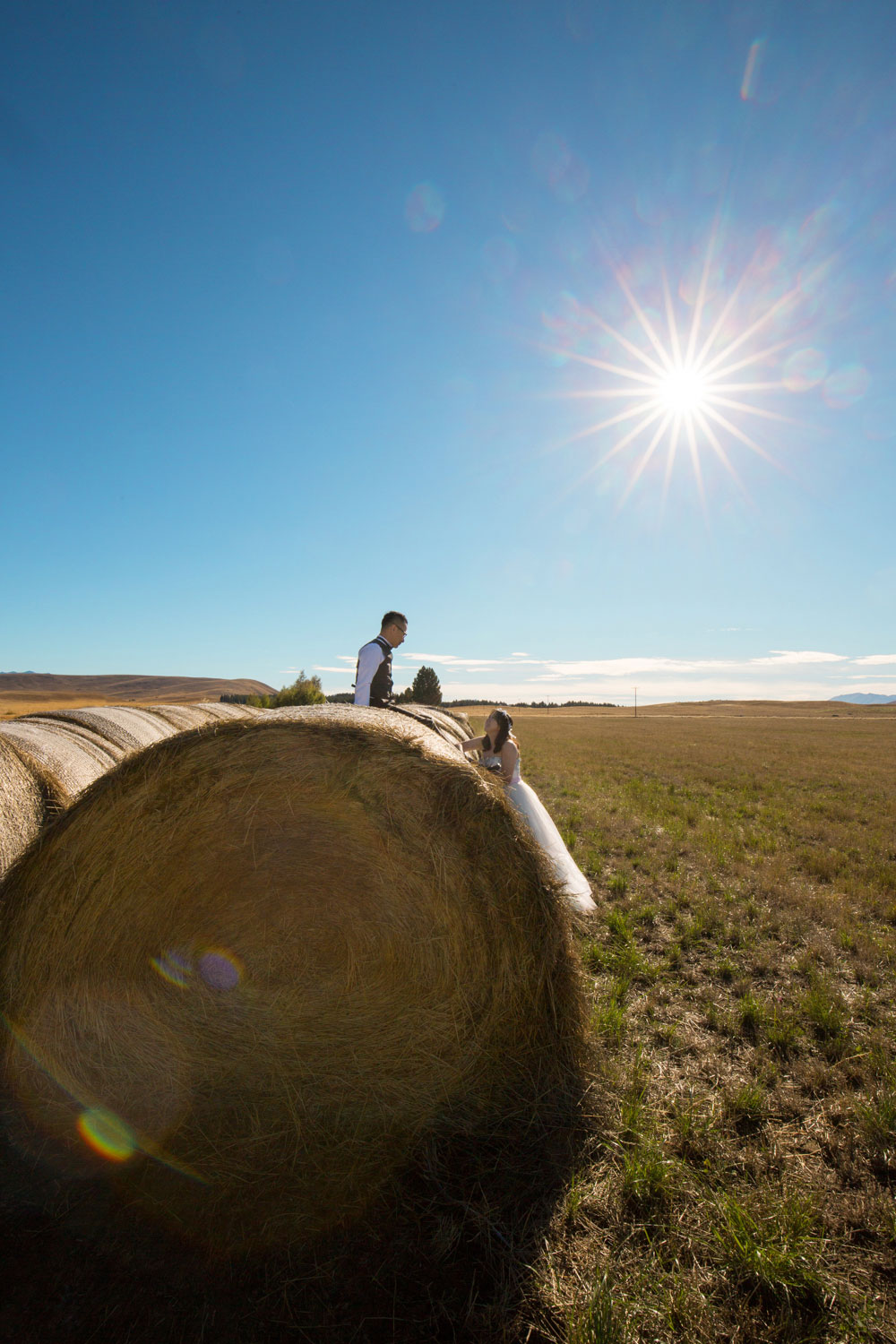 couple sitting on hay bale
