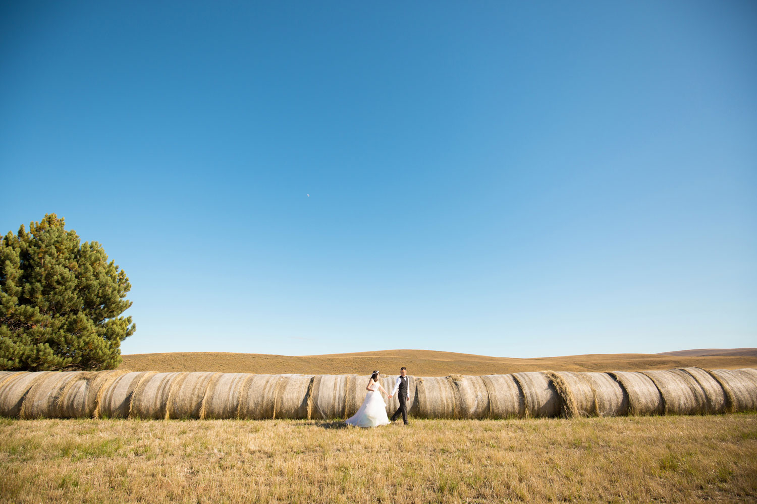 couple walking along hay bales