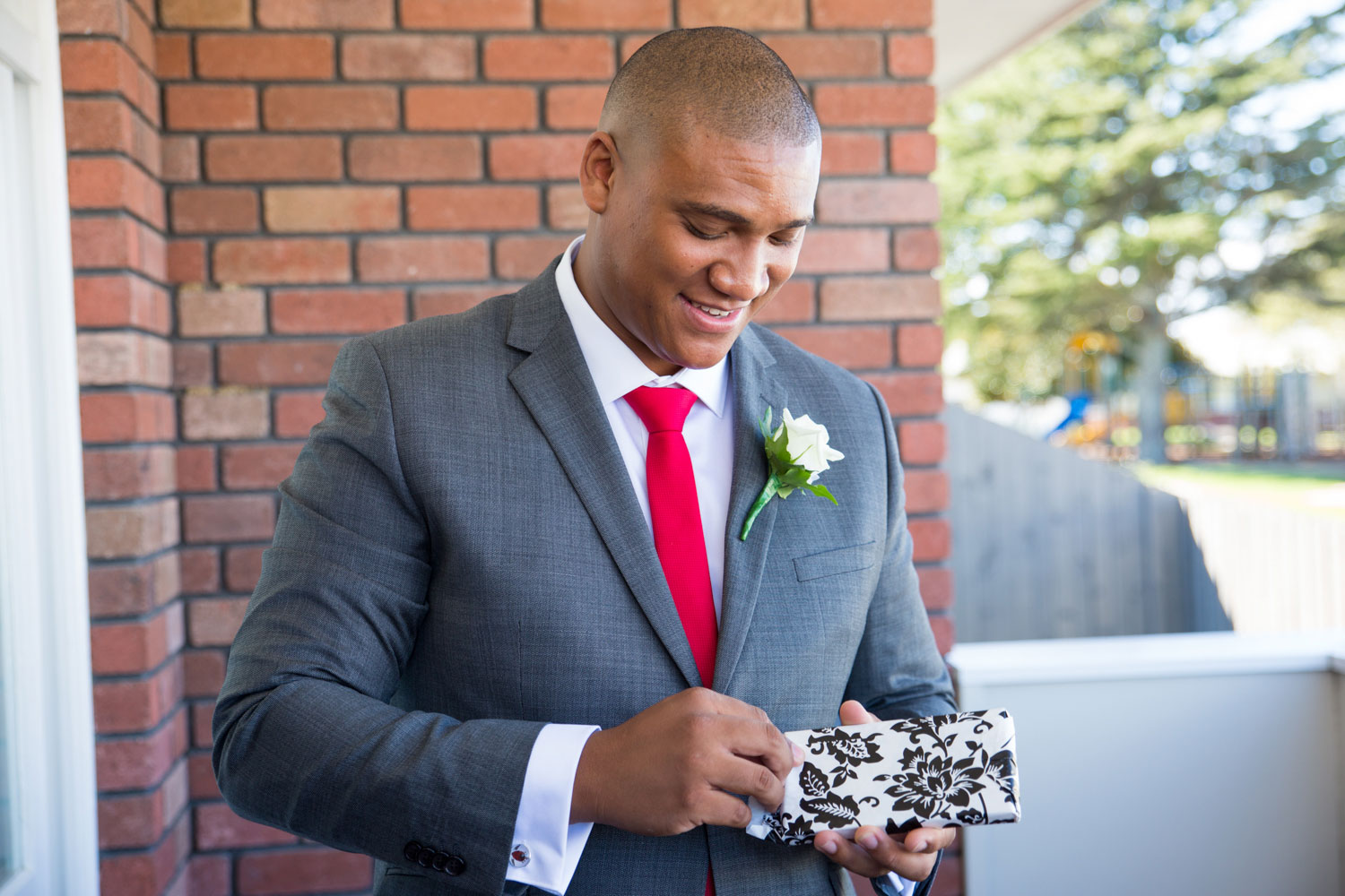 auckland wedding groom opening up a gift from the bride