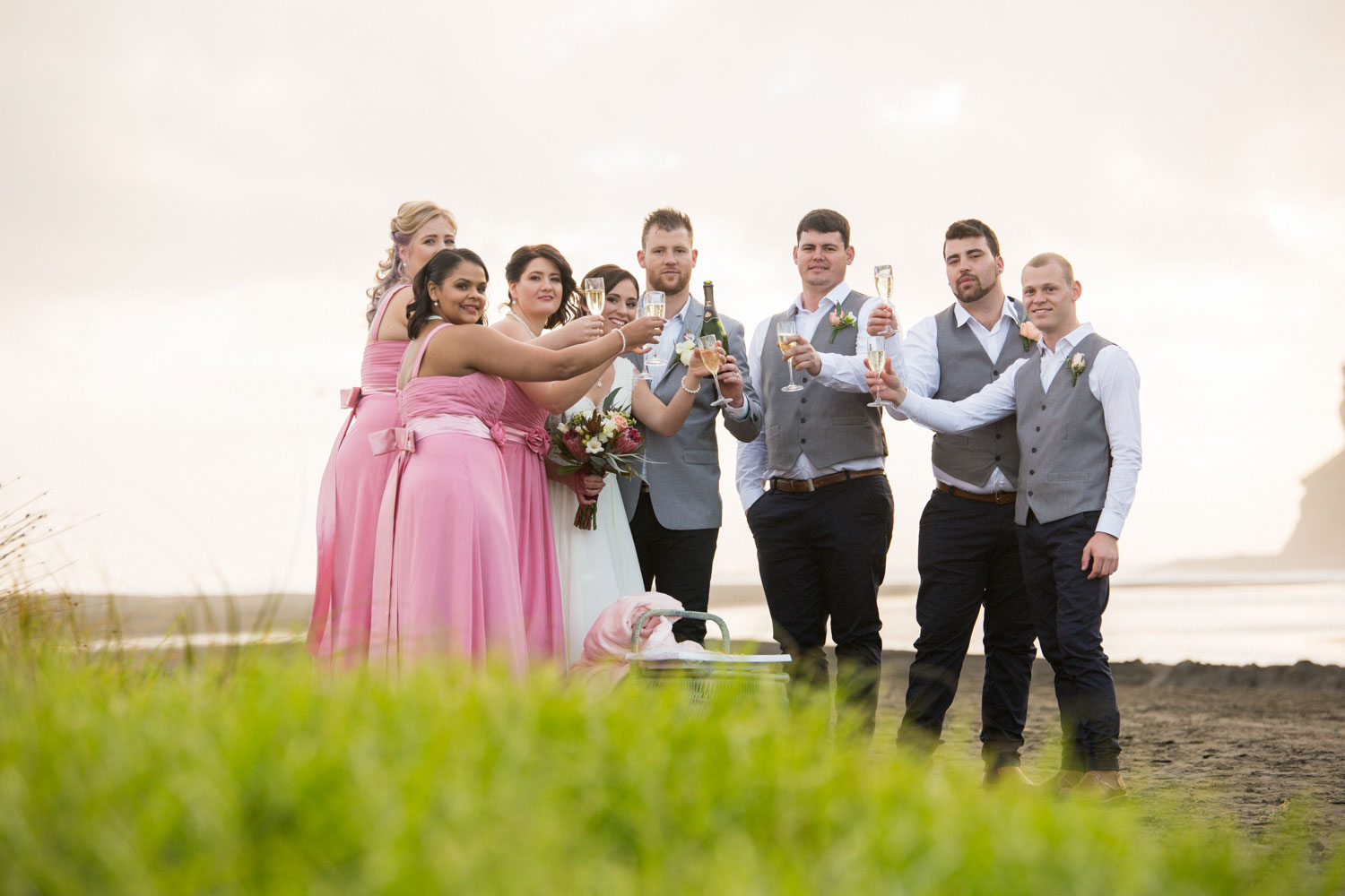 bridal party toasting on bethells beach