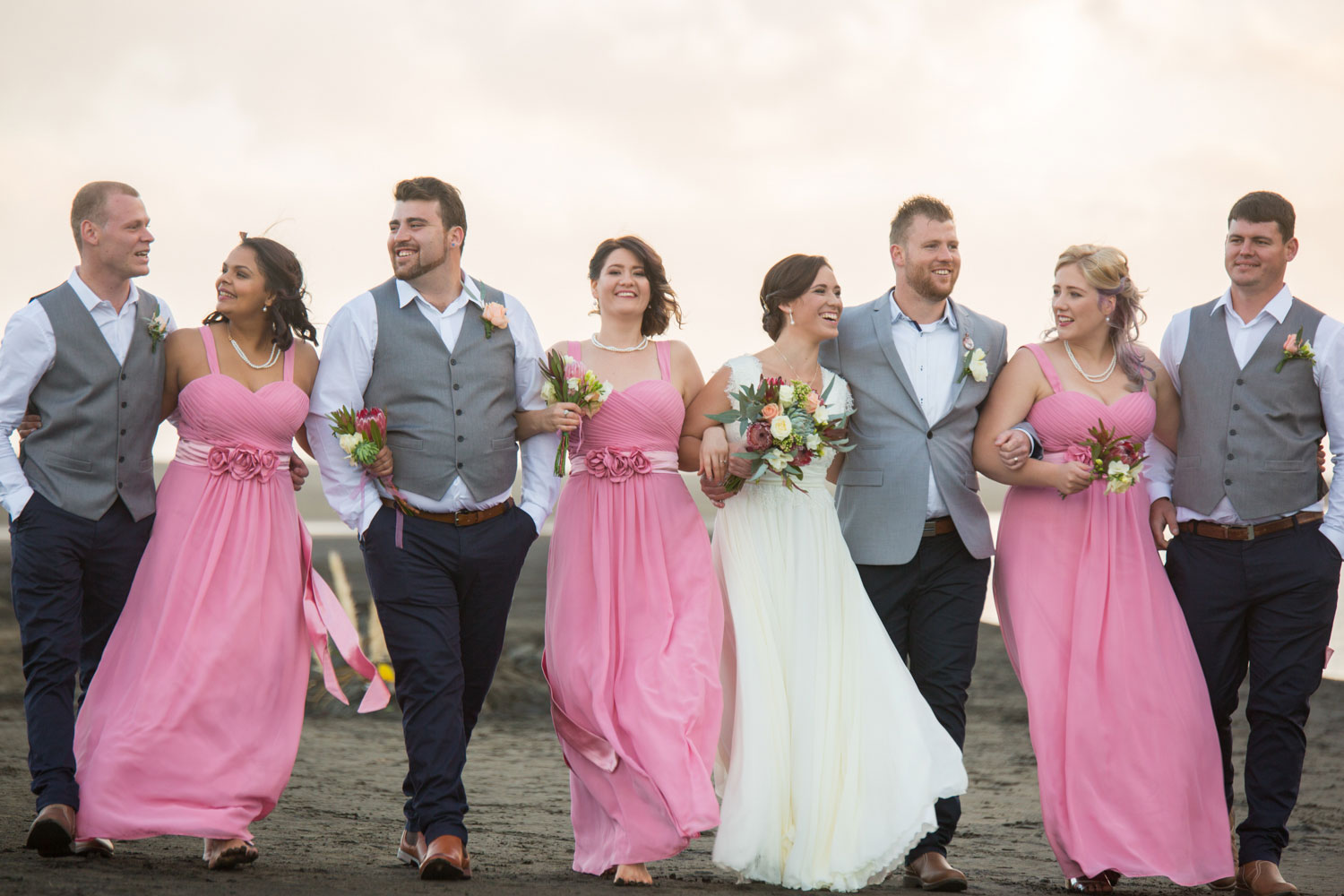 bridal party talking and laughing bethells beach