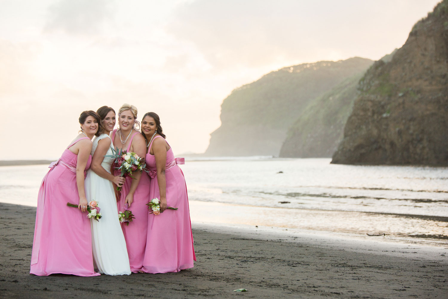 bride and bridesmaids on bethells beach