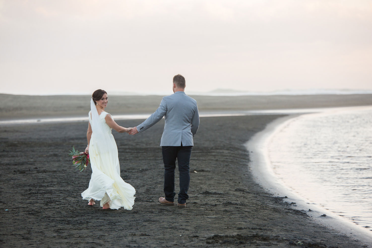 bride and groom walking on beach