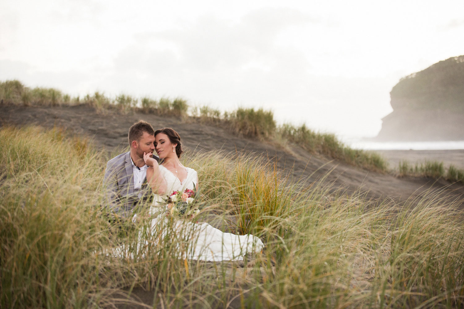 couple sitting at bethells beach