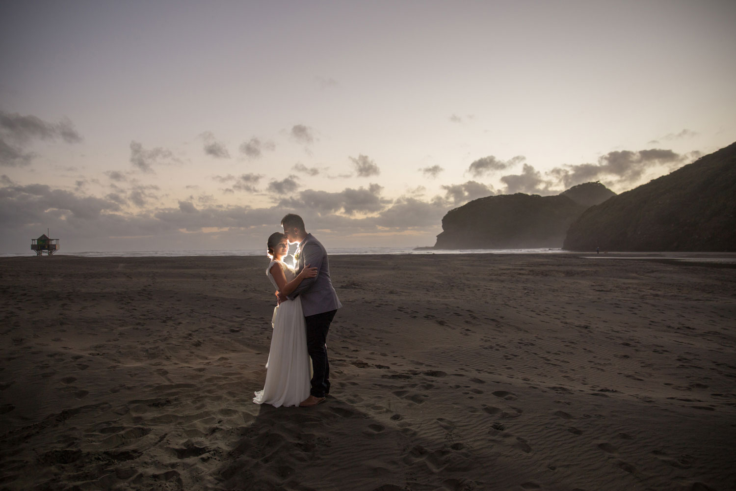 couple hugging on bethells beach