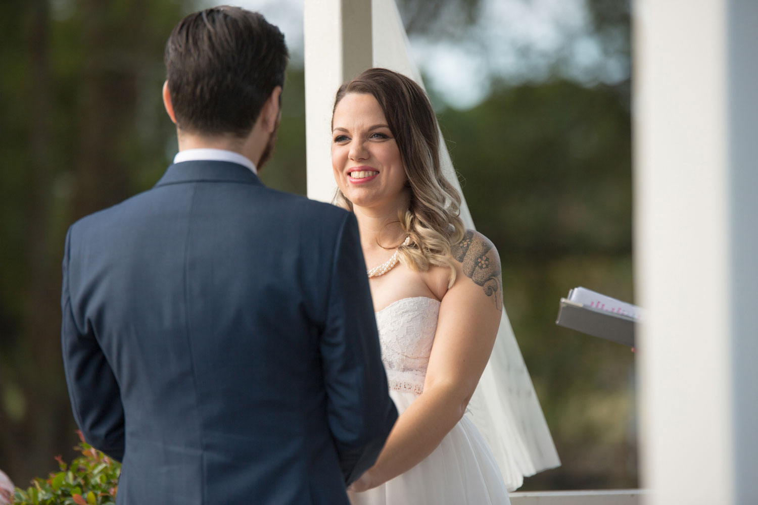 bride smiling at the groom during wedding ceremony