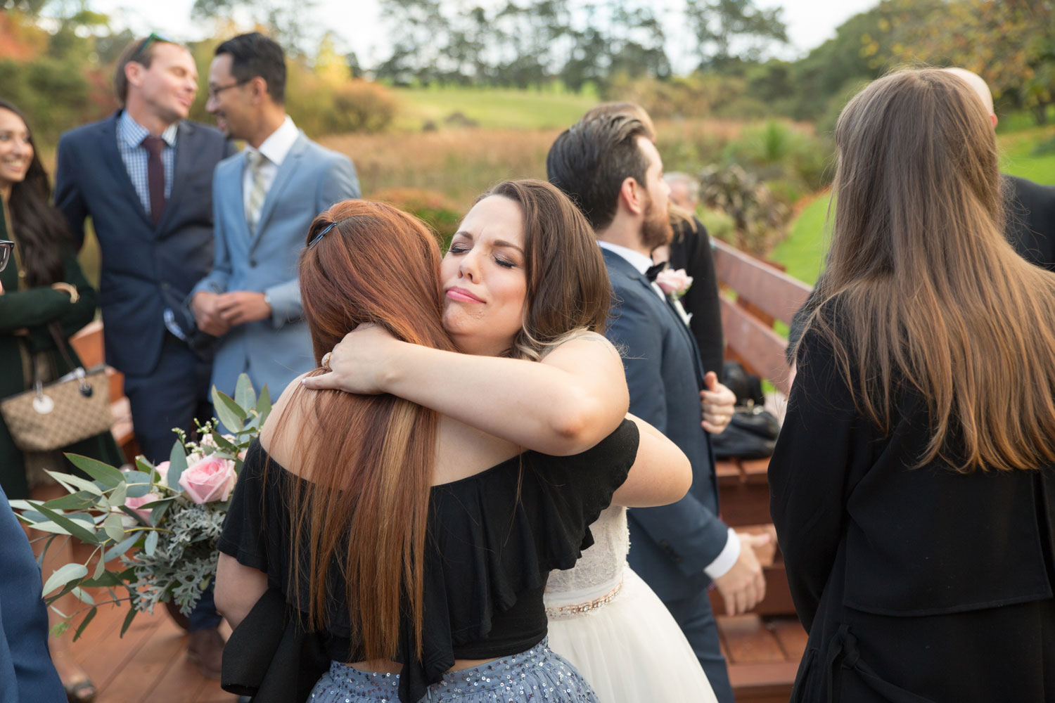 guest hugging bride after wedding ceremony