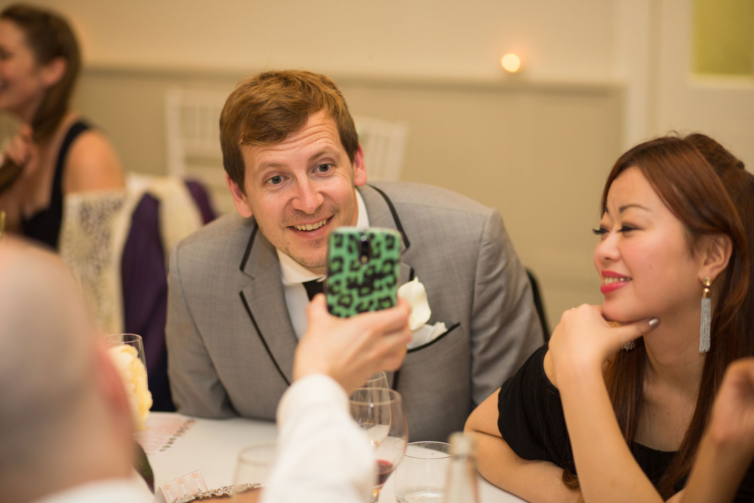 wedding guest looking at phone during reception