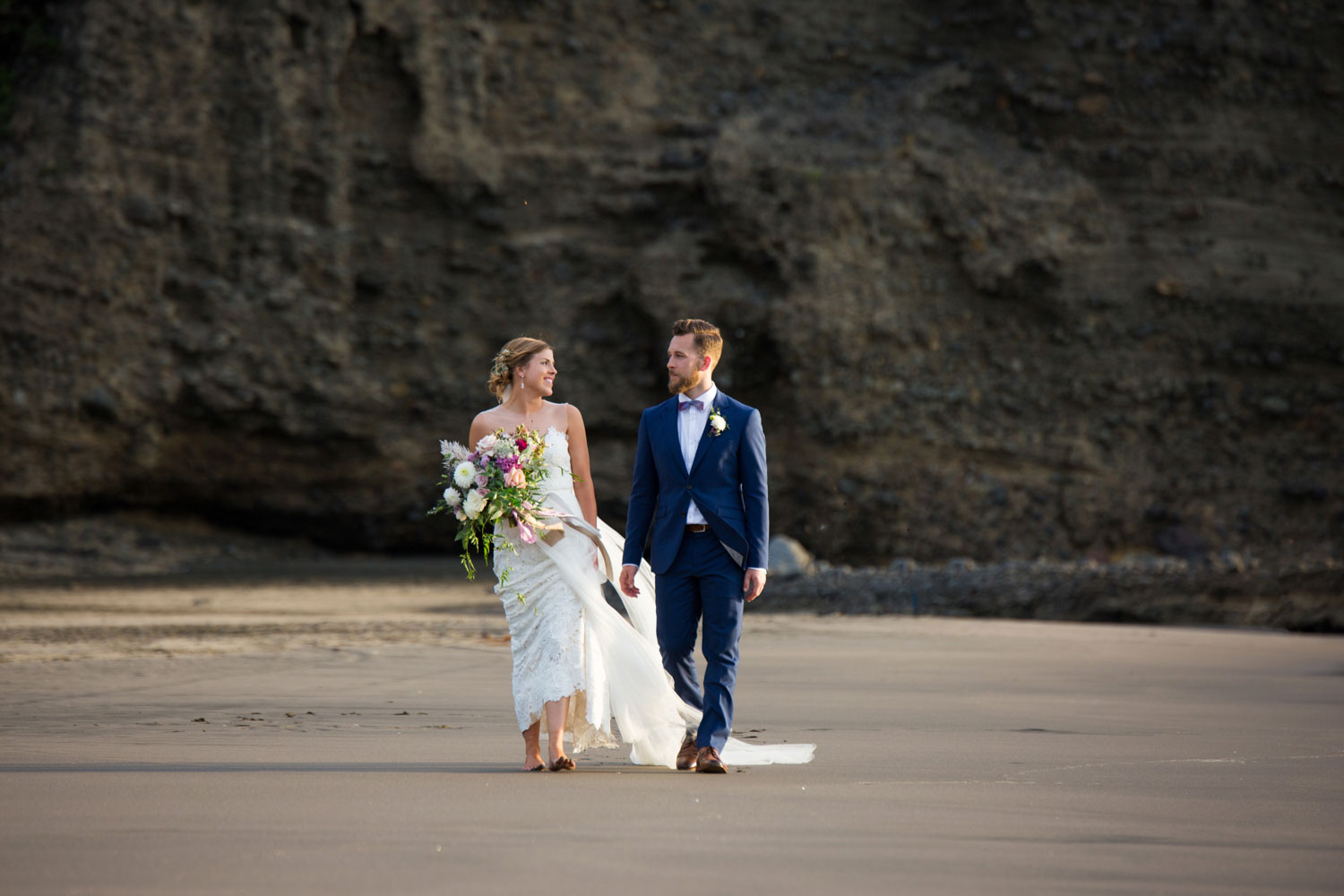 auckland wedding couple walking on beach