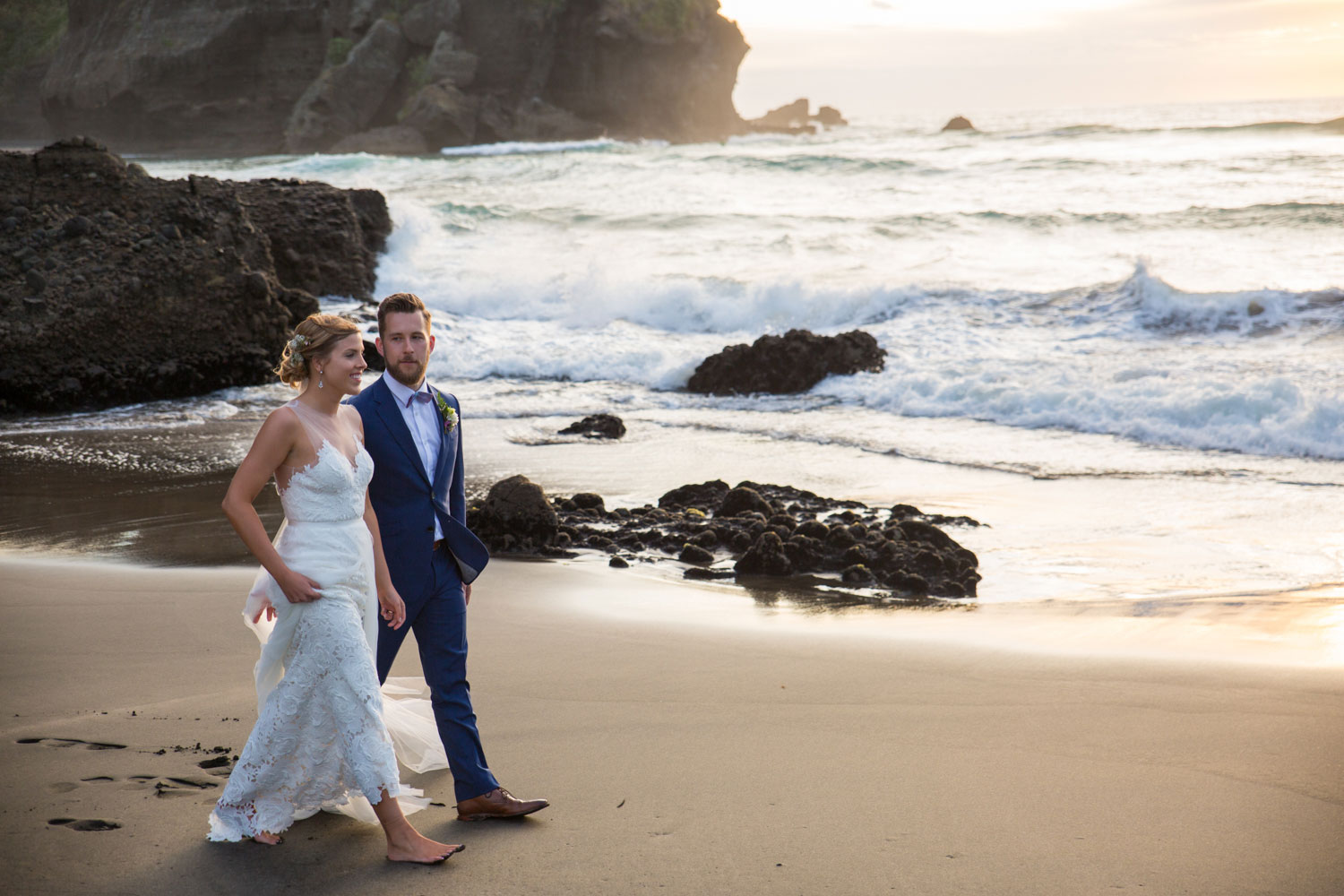 auckland wedding couple walking along piha beach