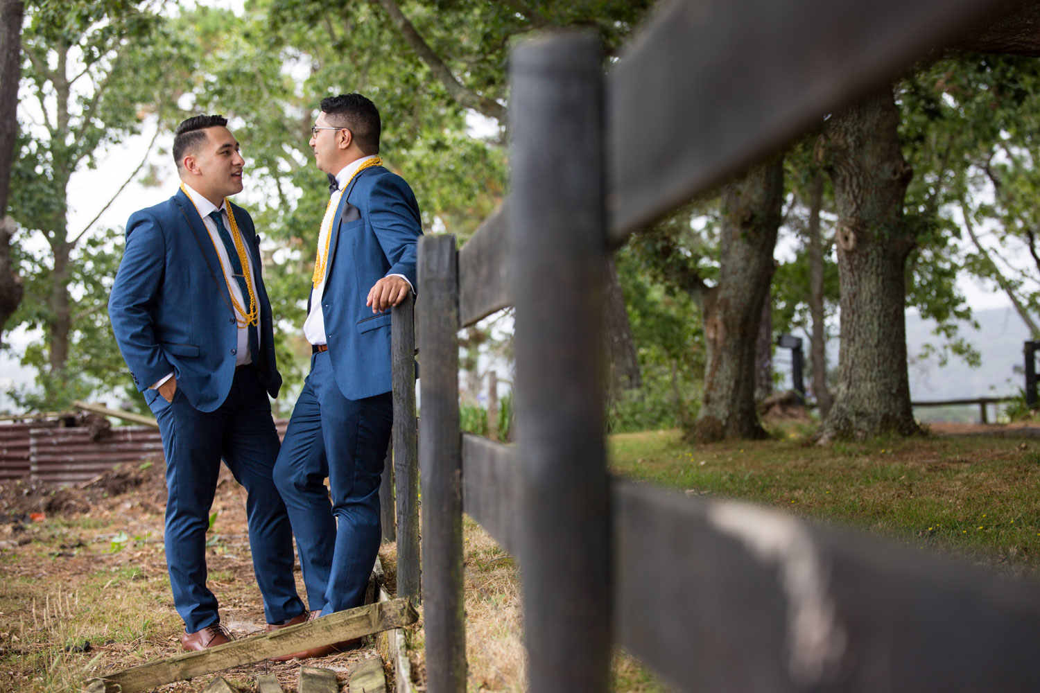 auckland wedding couple leaning against a fence