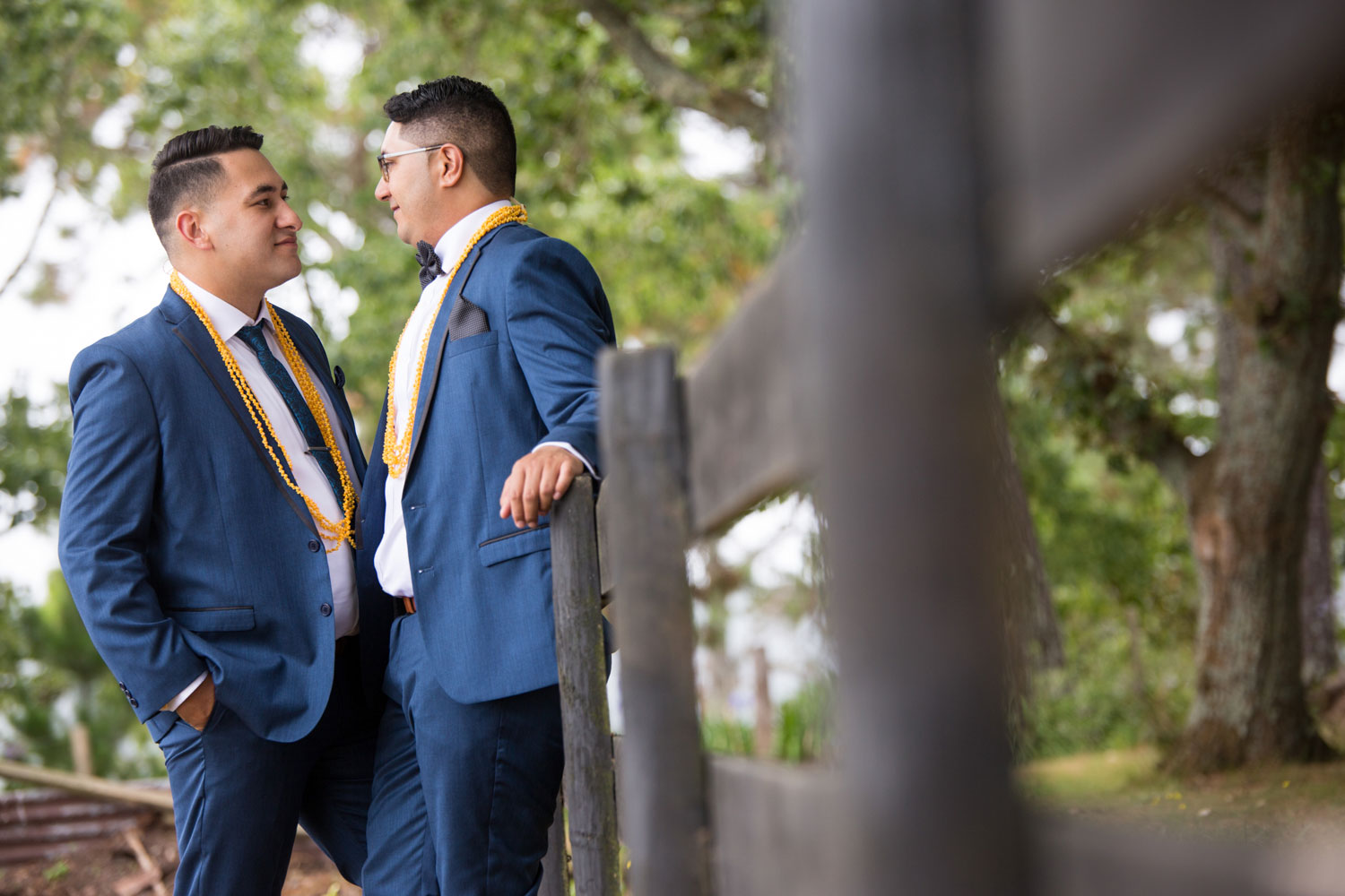 auckland wedding groom leaning against fence