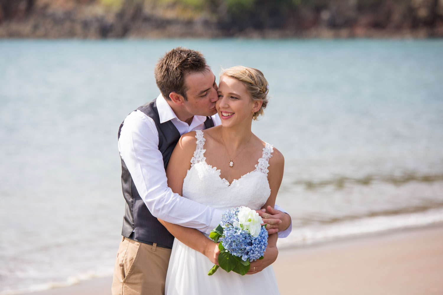 beach wedding groom kisses the bride