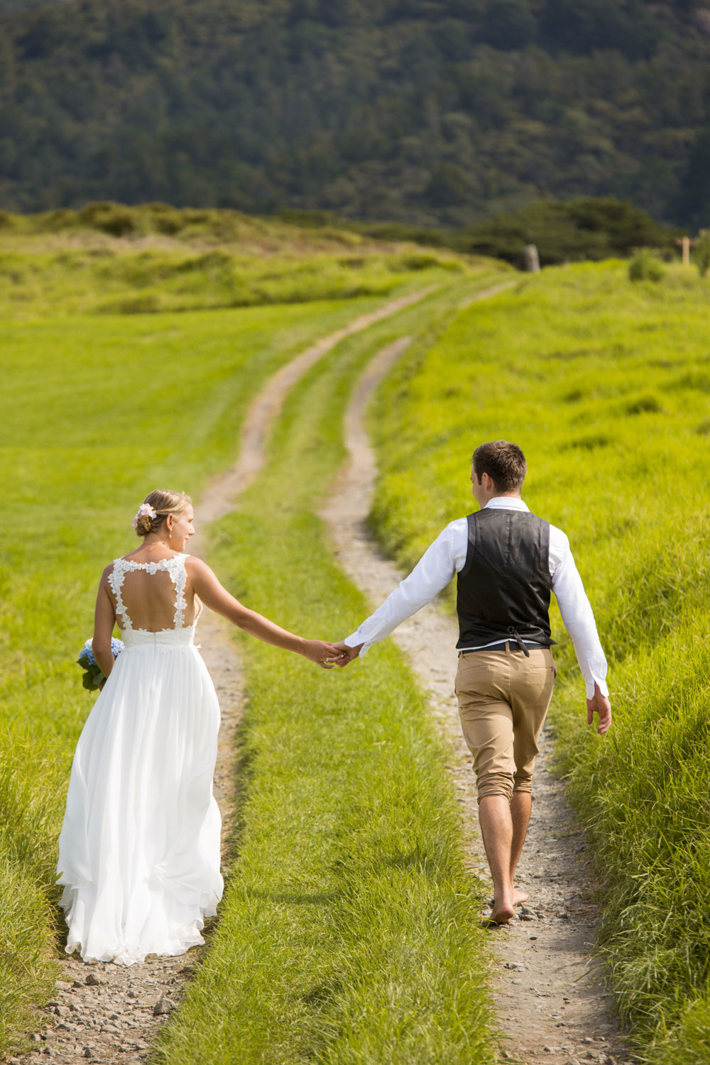 beach wedding couple holding hands walking