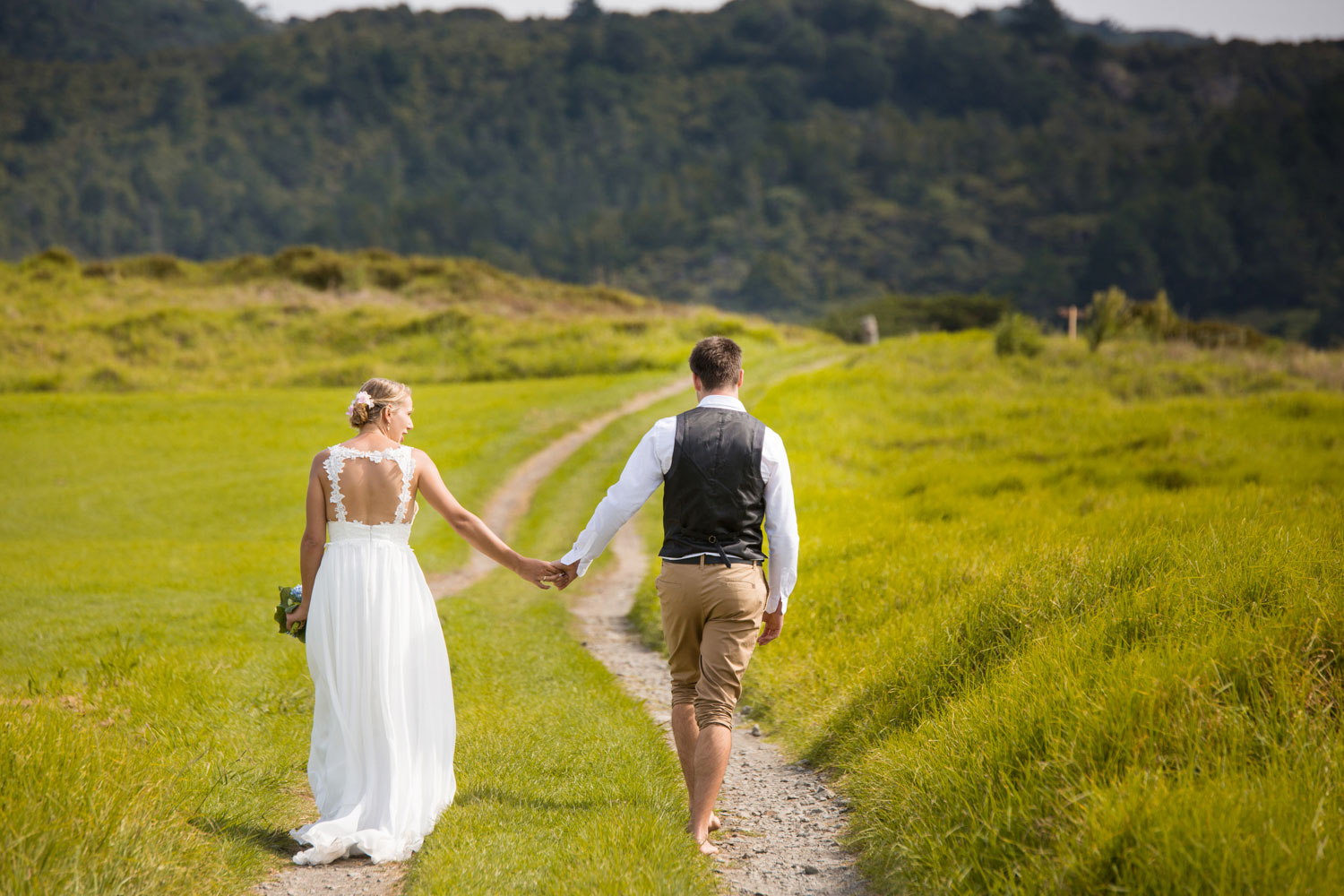 beach wedding couple hold hands walking