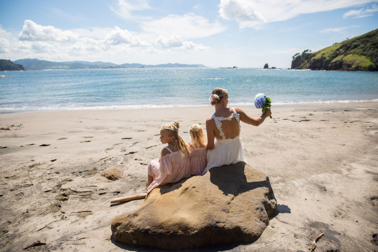 great barrier island bride sitting on rocks