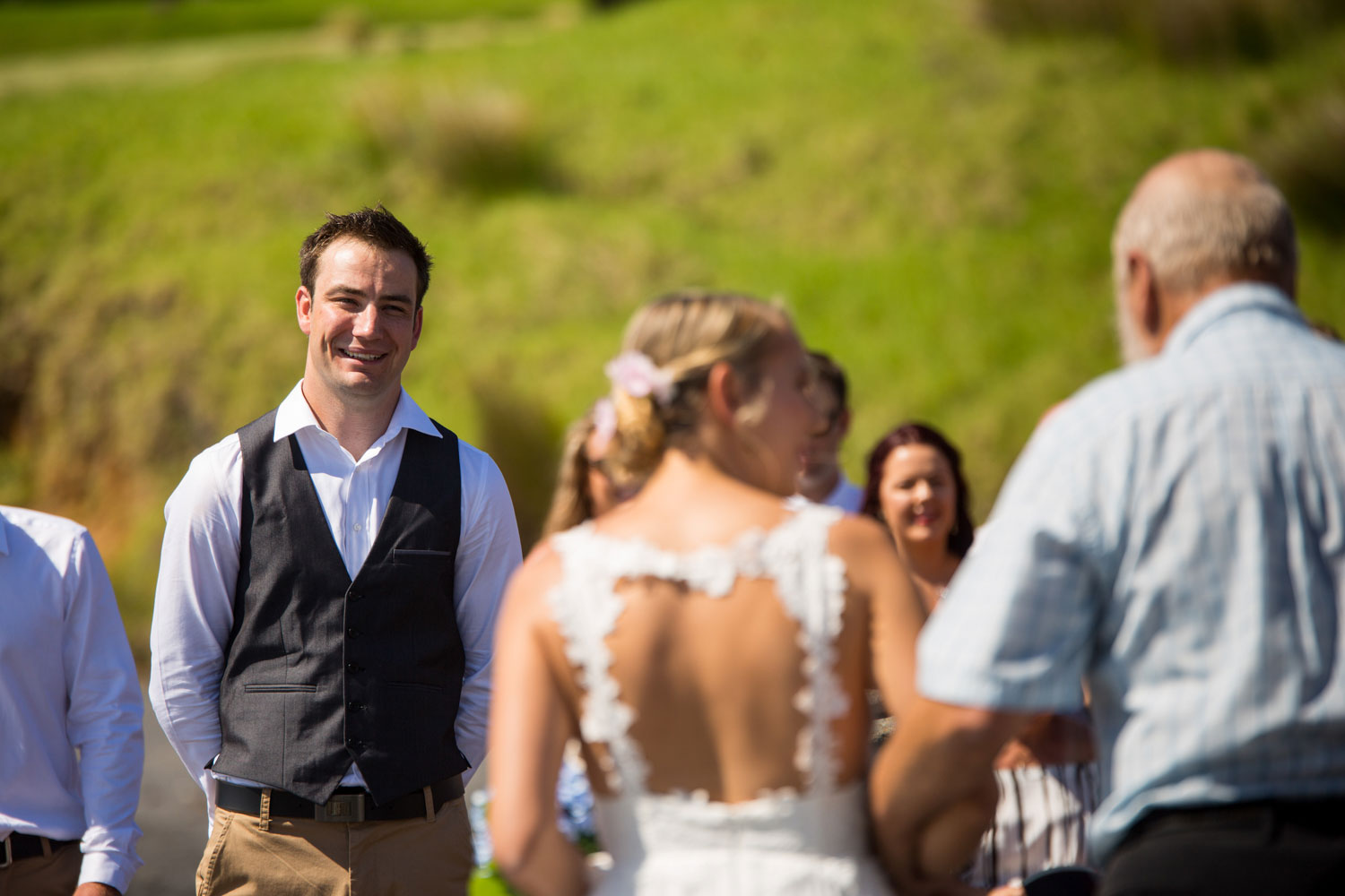 beach wedding photos groom reacting to bride