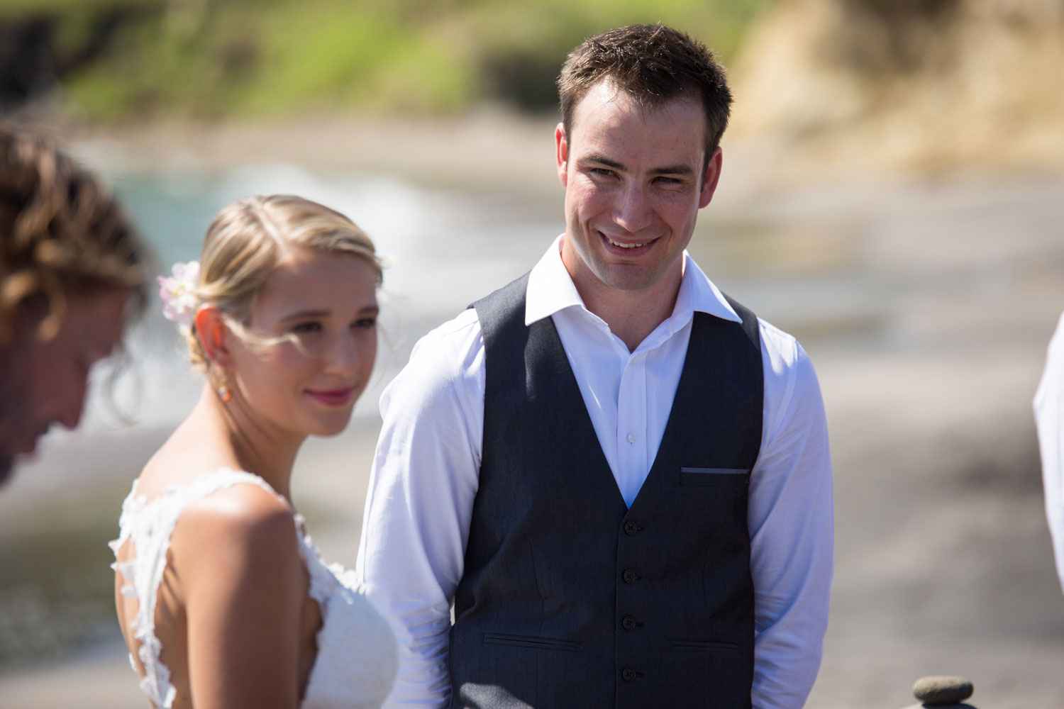 beach wedding photos groom looking at bride