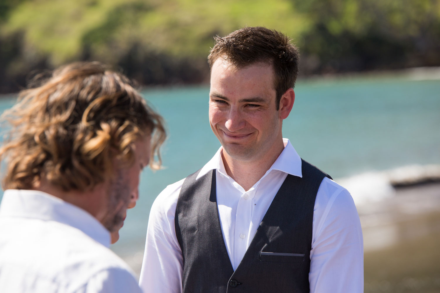 beach wedding groom smiling at bride