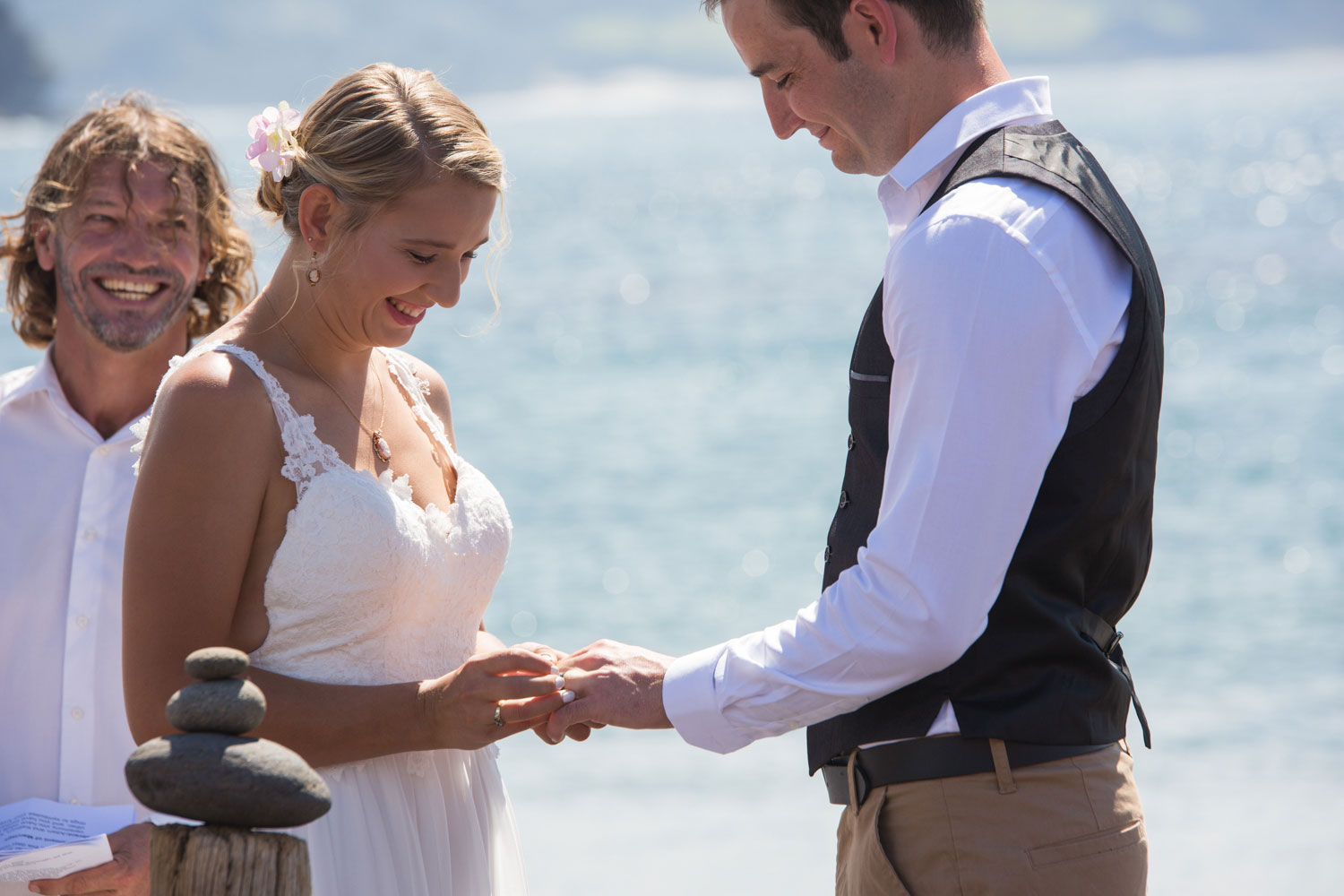 beach wedding bride putting on ring