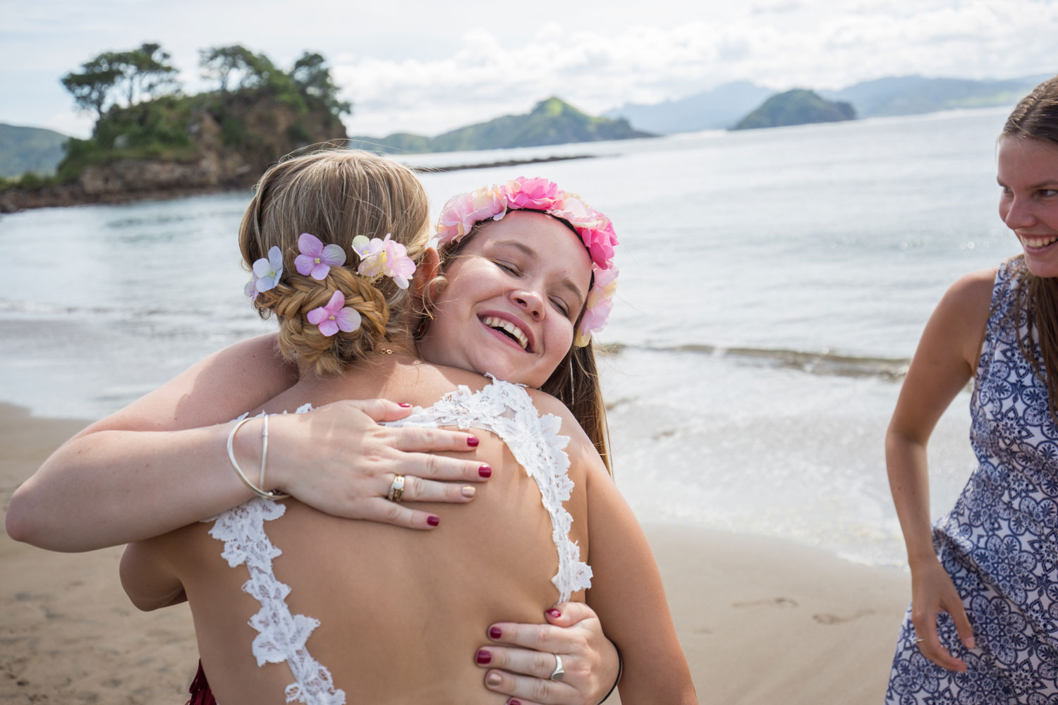 beach wedding guest hugging bride