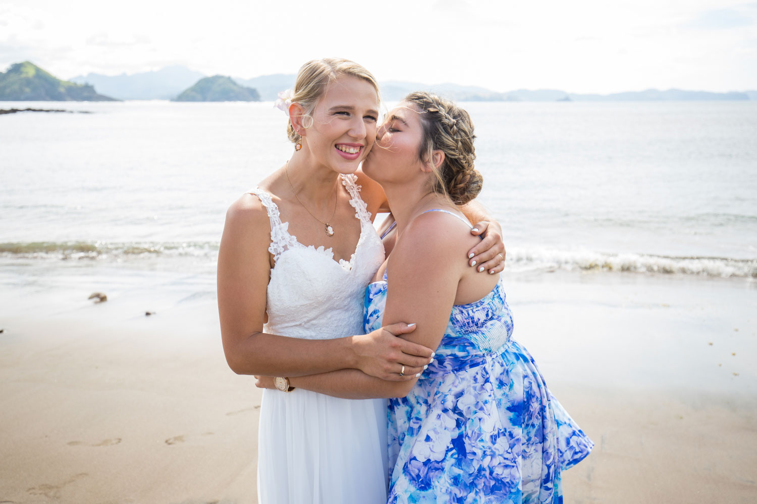 beach wedding guest kissing bride