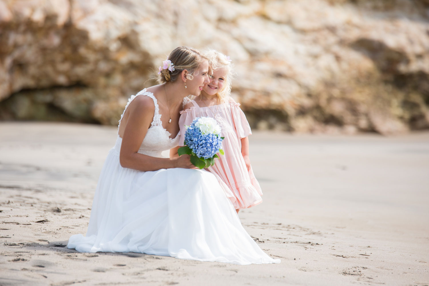 beach wedding bride kissing flower girl