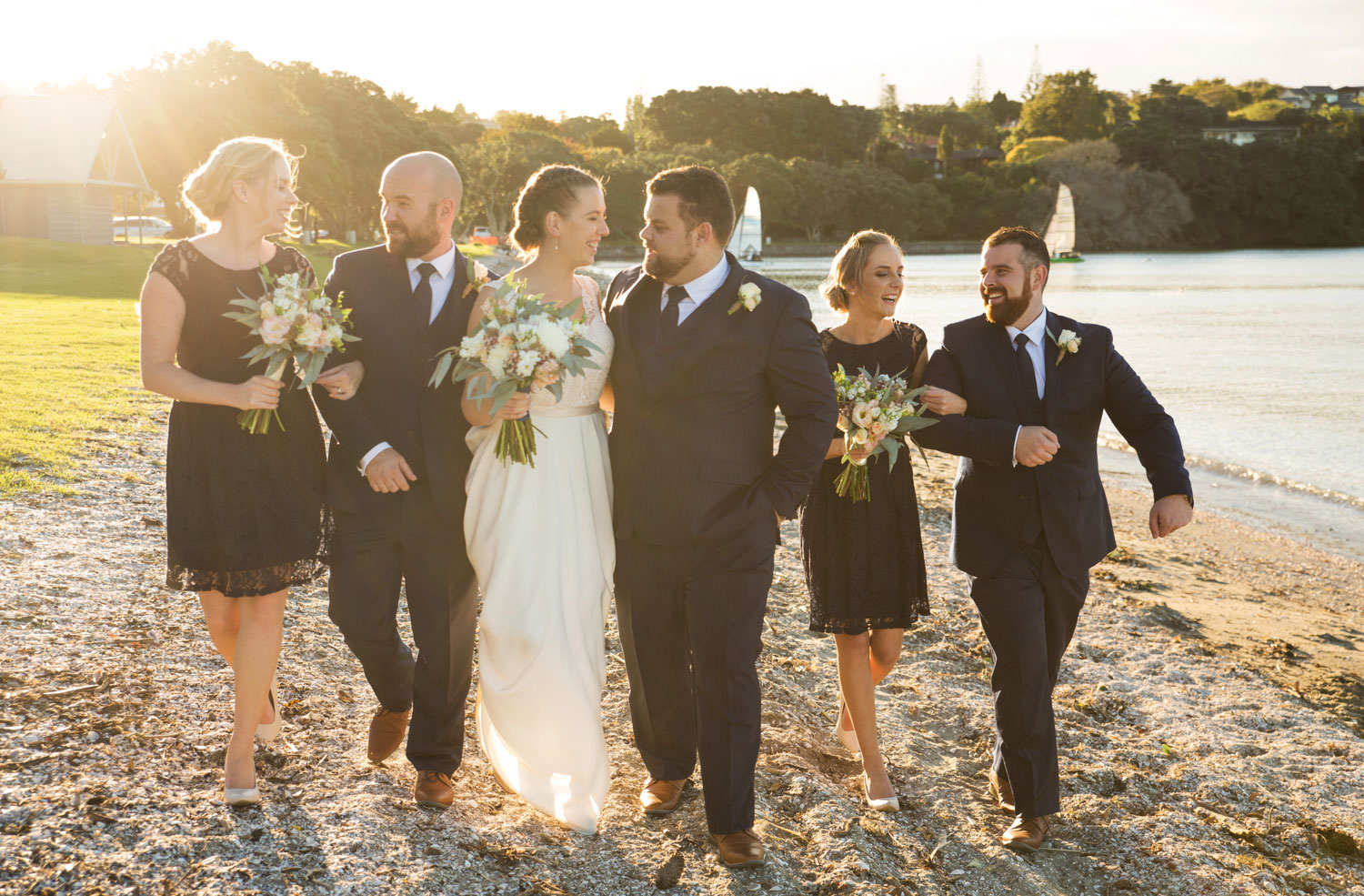 wedding photographer auckland bridal party walk on beach