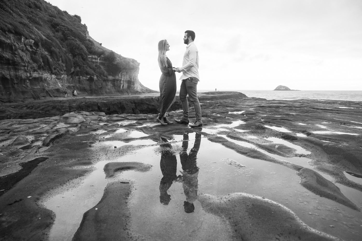 muriwai beach engagement photo of the couple reflection