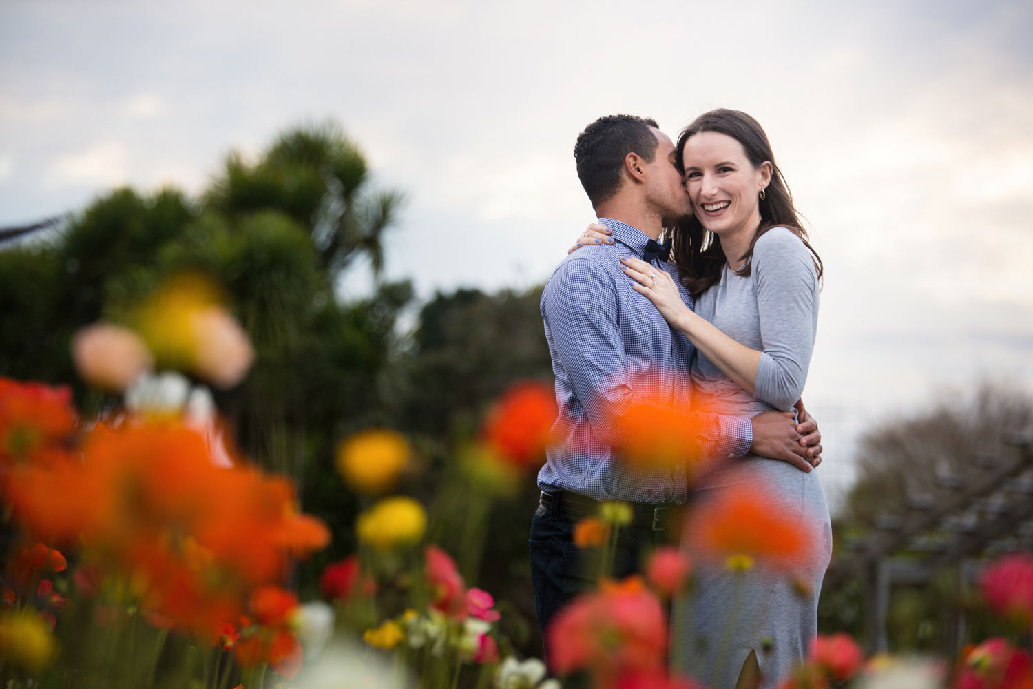 auckland botanic gardens engagement photo groom kissing bride behind tulips