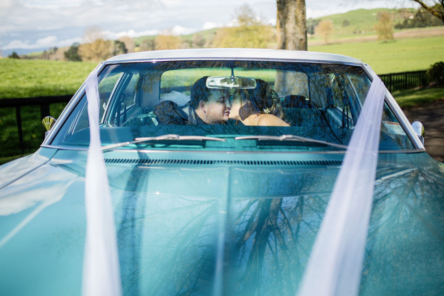 the red barn waikato wedding couple in car kissing