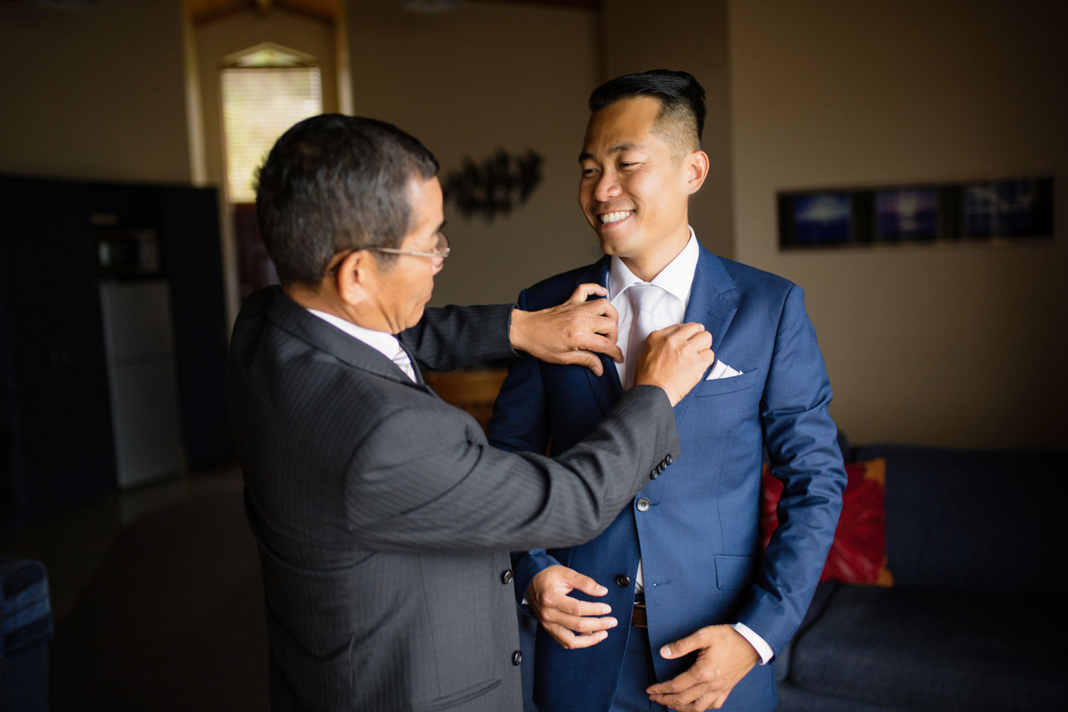 castaways waiuku wedding father putting on jacket for groom