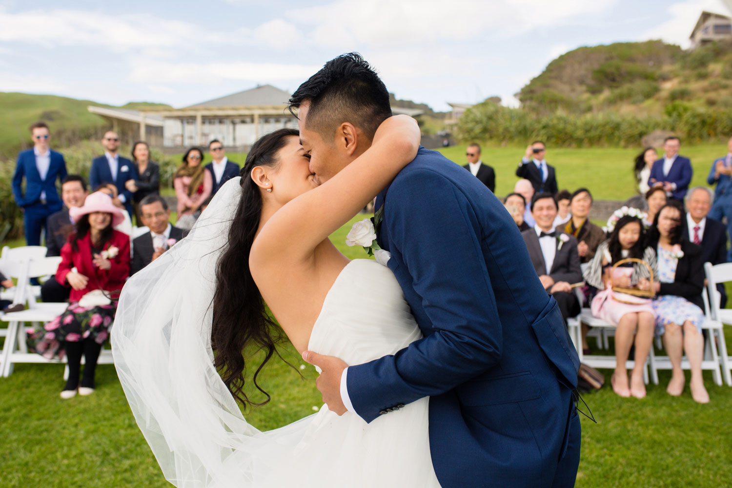 castaways waiuku wedding bride and groom kissing in front of guests