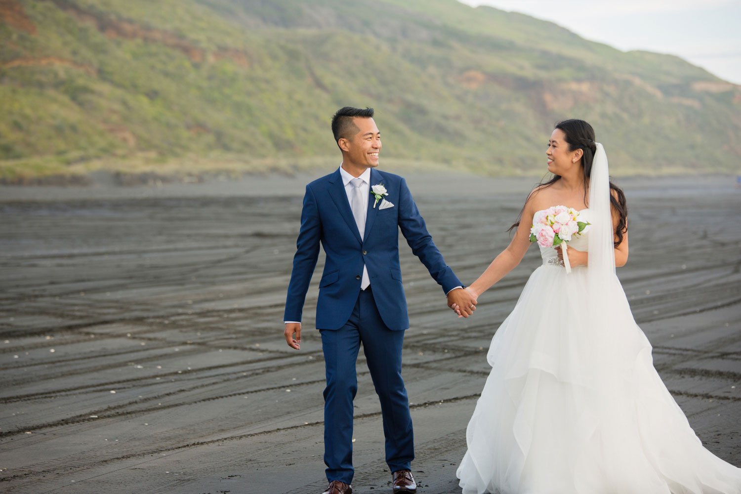 castaways waiuku wedding groom and bride walking on the beach