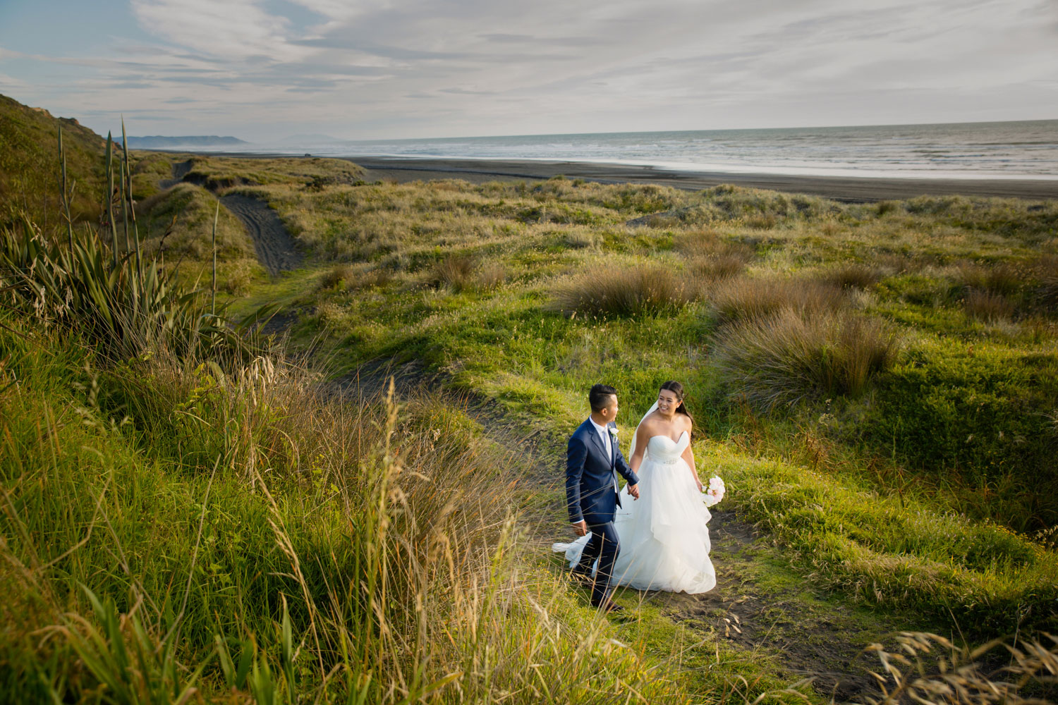 castaways waiuku wedding bride and groom walking back to reception