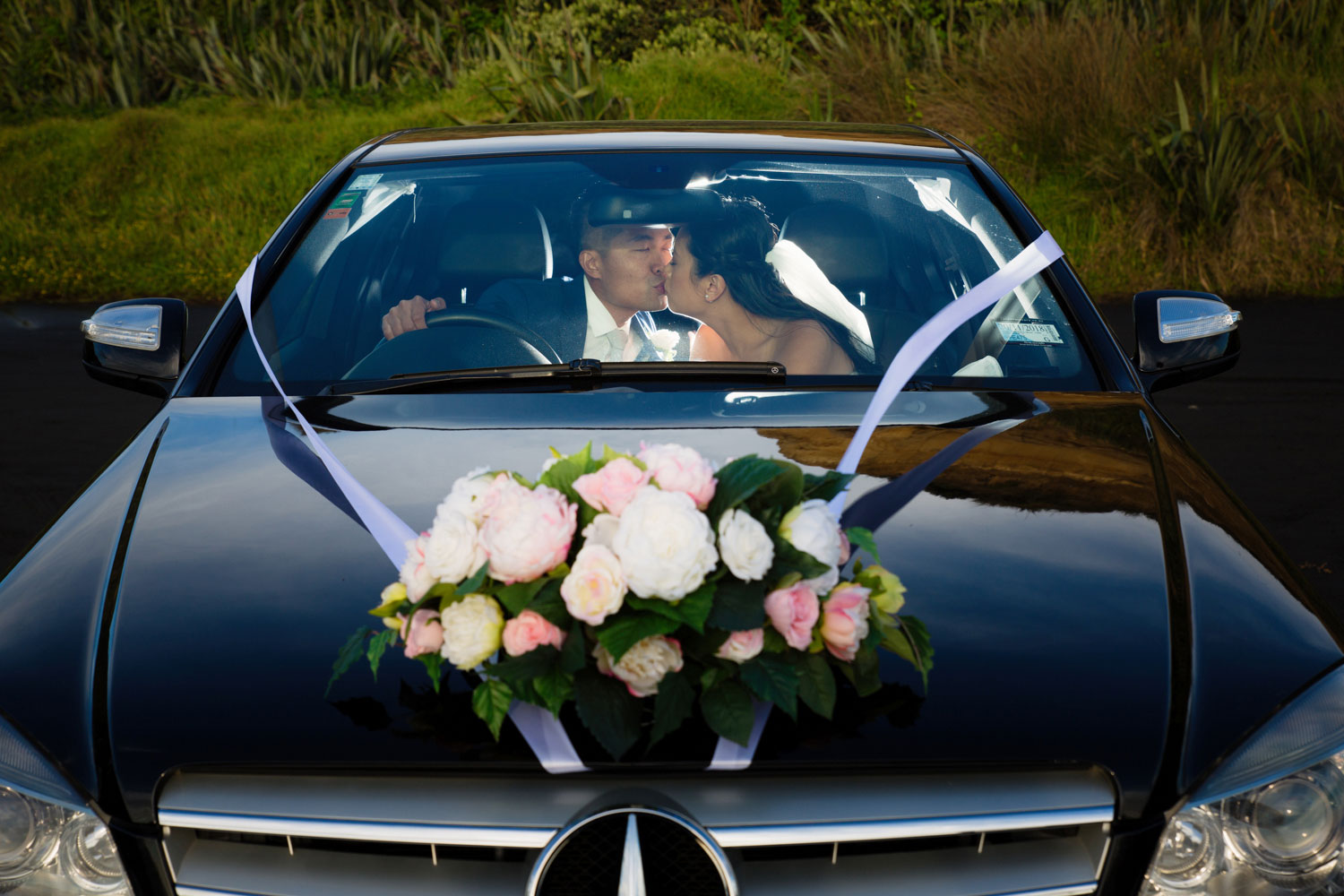 castaways waiuku wedding bride and groom kissing in the car