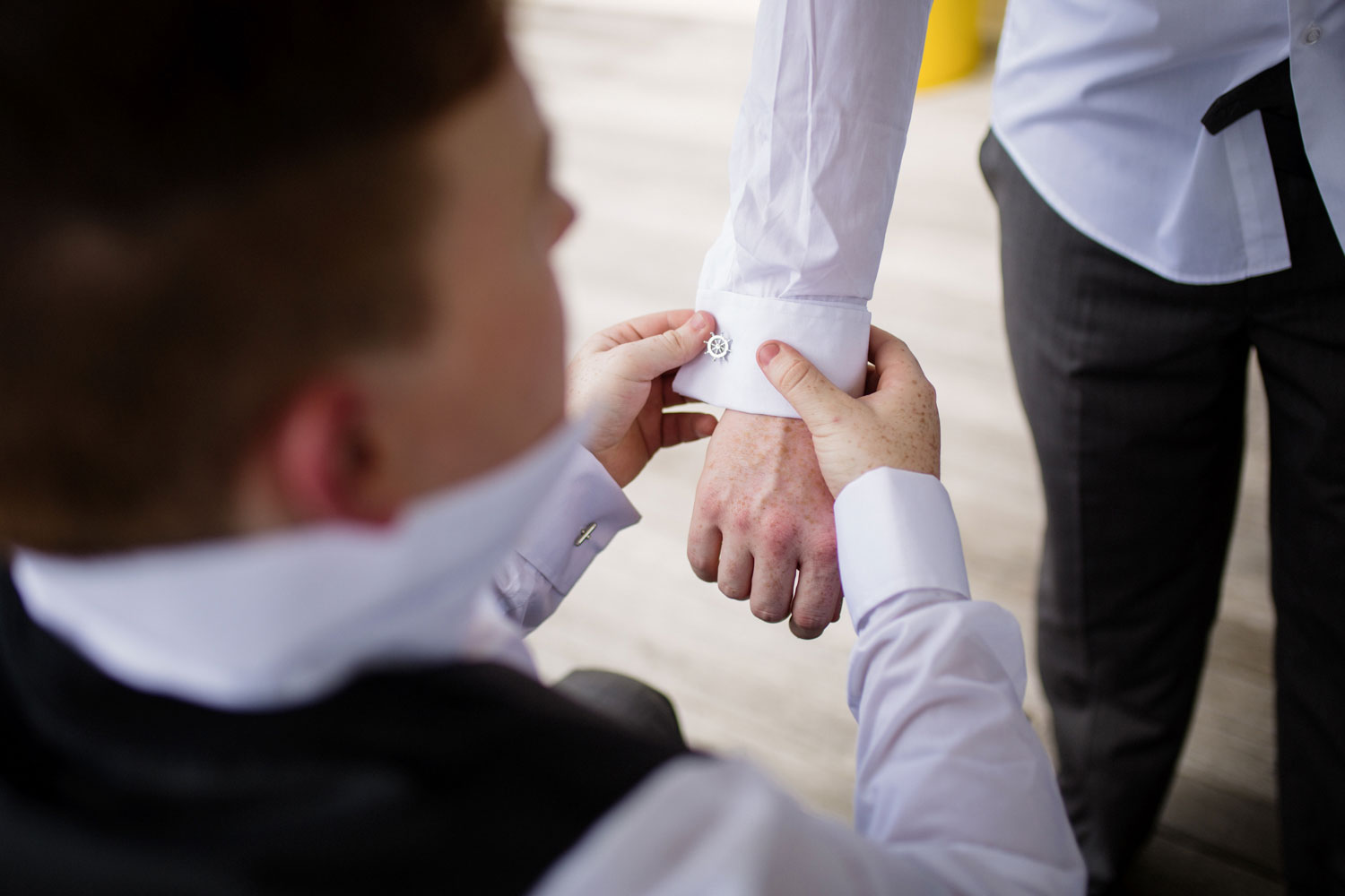 groom putting on cufflinks