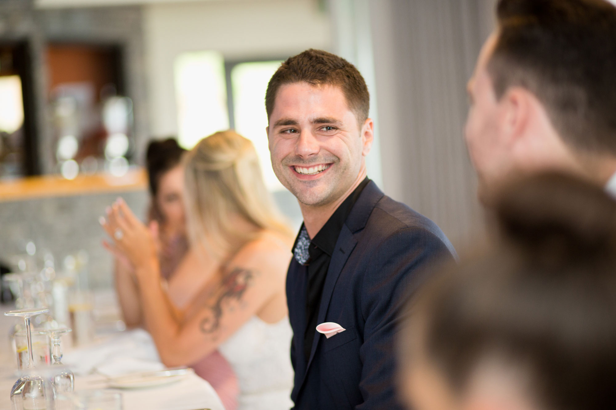 groom smiling at a guest