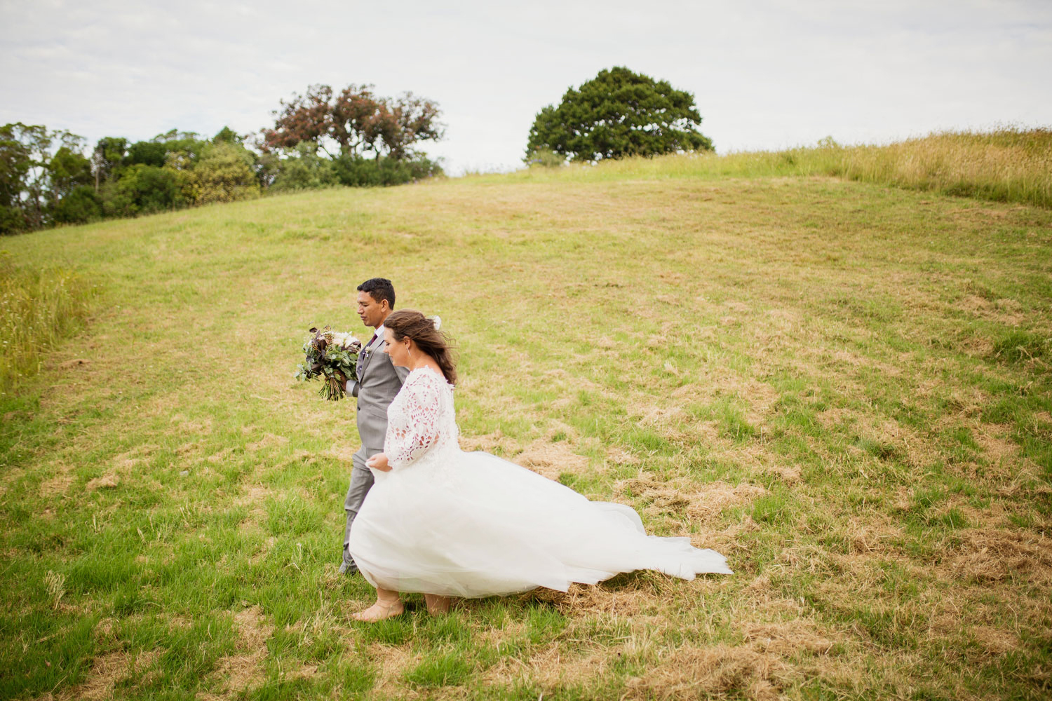 bride and groom walking across field