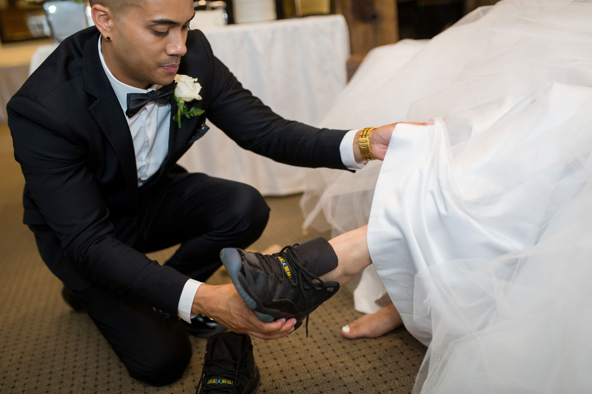 groom putting on shoe for bride