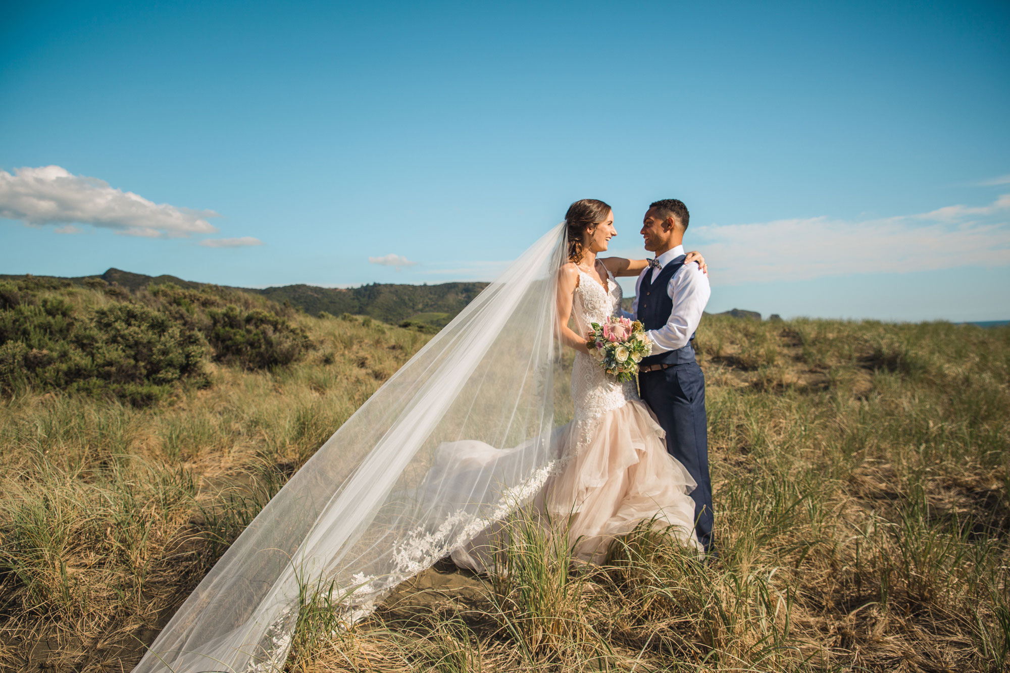 bride and groom at bethells beach