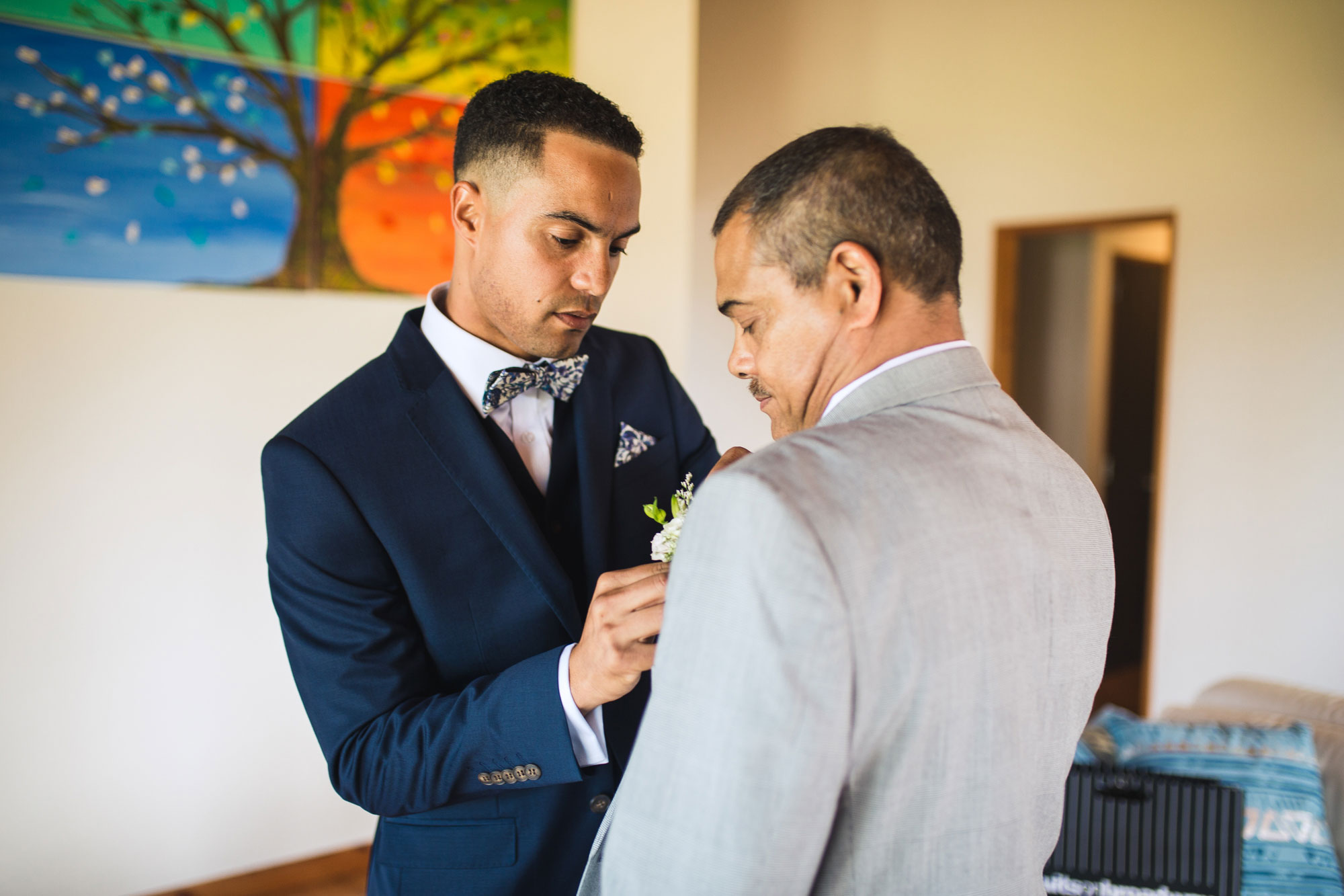 groom putting on boutonniere